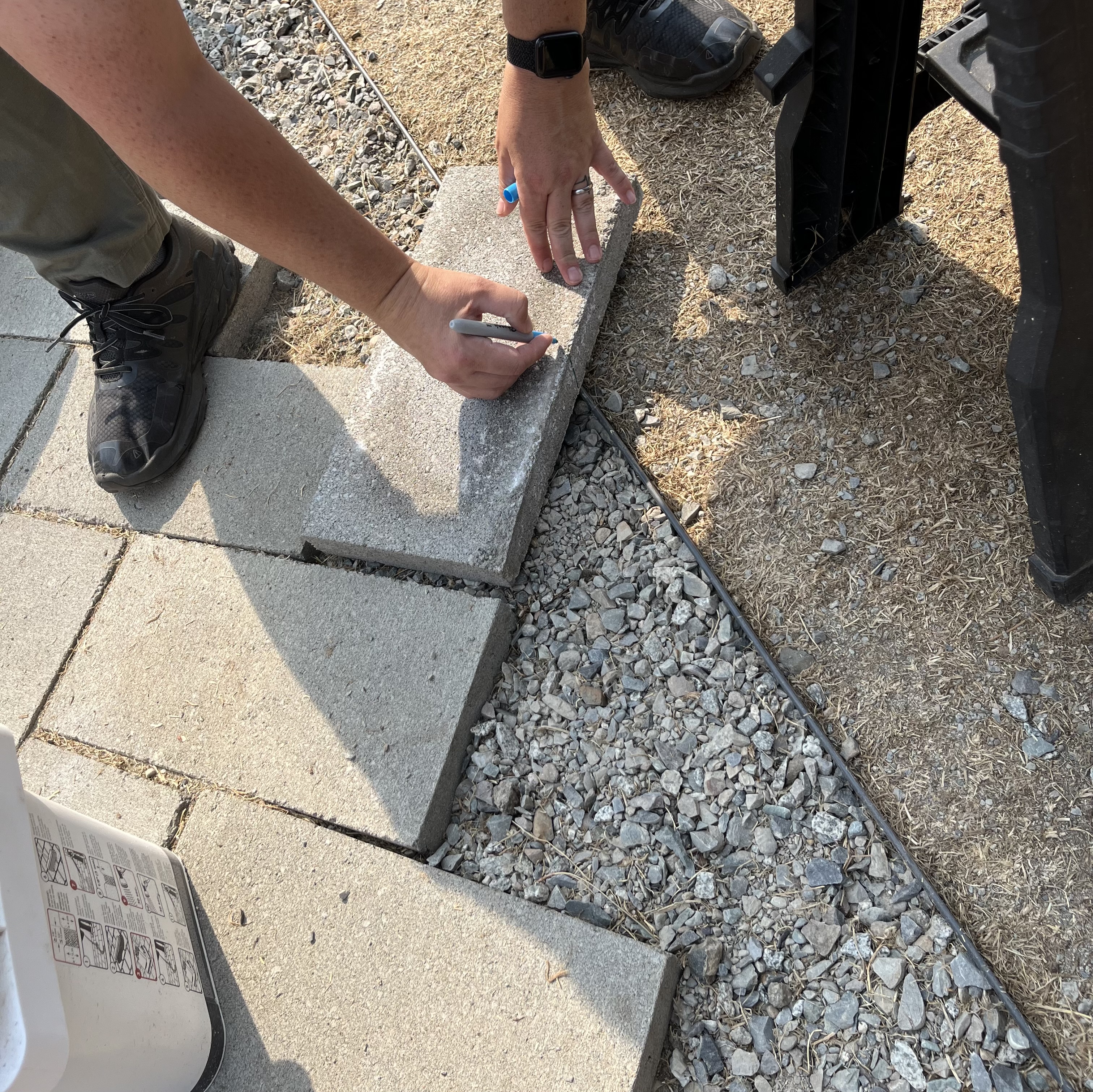 paver out of place on patio getting marked to be cut.